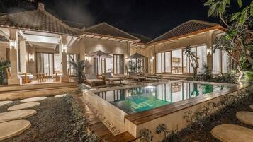 A poolside area with lounge chairs and a swimming pool.