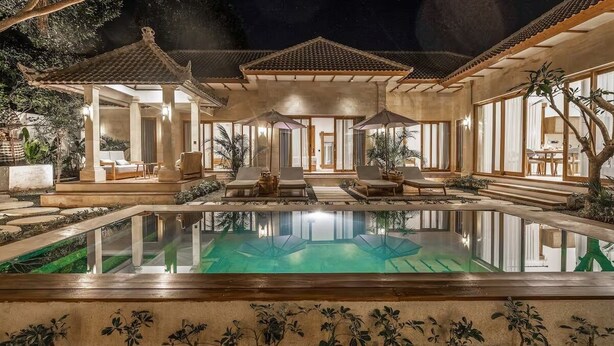 Ein Poolbereich mit Liegestühlen und klarem Wasser.