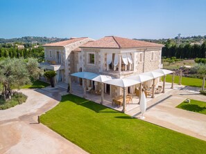 A stone villa with a tiled roof, outdoor seating, and a well-maintained lawn. - Villa mit Jacuzzi by Interhome (Selva)