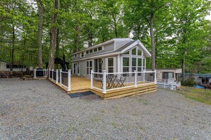 A cabin with a deck, surrounded by trees. - The Nook Tiny Home Fire Pit Close to Lake (Eagle Lake)
