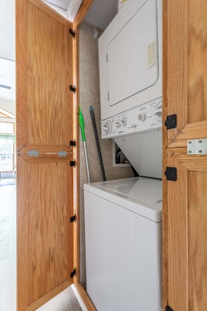 A compact laundry area with a washing machine and a drying rack. - The Nook Tiny Home Fire Pit Close to Lake (Eagle Lake)