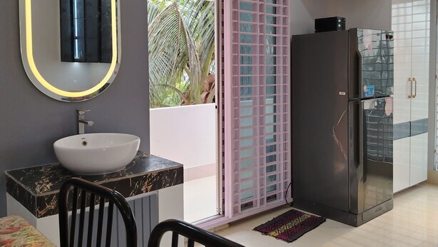 Una cocina moderna con un lavamanos, espejo y refrigerador.