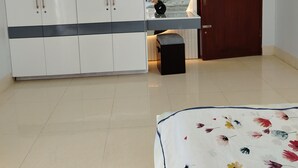 Un dormitorio con una cama, un armario, una mesita y una puerta.