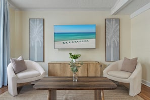 A room with two beige armchairs, a wooden coffee table, a potted plant, and a beach-themed painting on the wall. - NEW! Okaloosa Island, Destin, Navarre
3 bedroom/ 2 bath, pool, beach gear (Mary Esther)