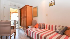 Un dormitorio con cama, armario de madera, silla y mesa de comedor.