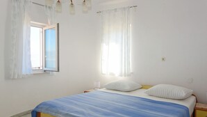 A bedroom with a bed, curtains, a window, and a bedside table. - Apartment Jako by Interhome (Trogir/Slatine)