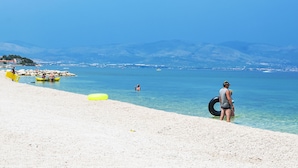 A beach with clear water, a rocky shoreline, and distant mountains. - Apartment Jako by Interhome (Trogir/Slatine)