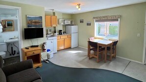 A compact living space with a kitchenette, a dining area, and a seating area. - Suite 11 Green Gables Resort, Lake View Retreat (Osoyoos)