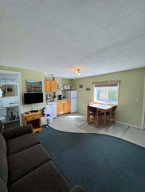 A compact living space with a kitchenette, a dining area, and a seating area.