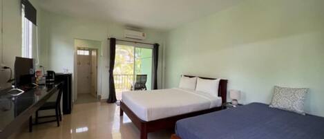 A hotel room with two beds, a desk, a chair, and a window.