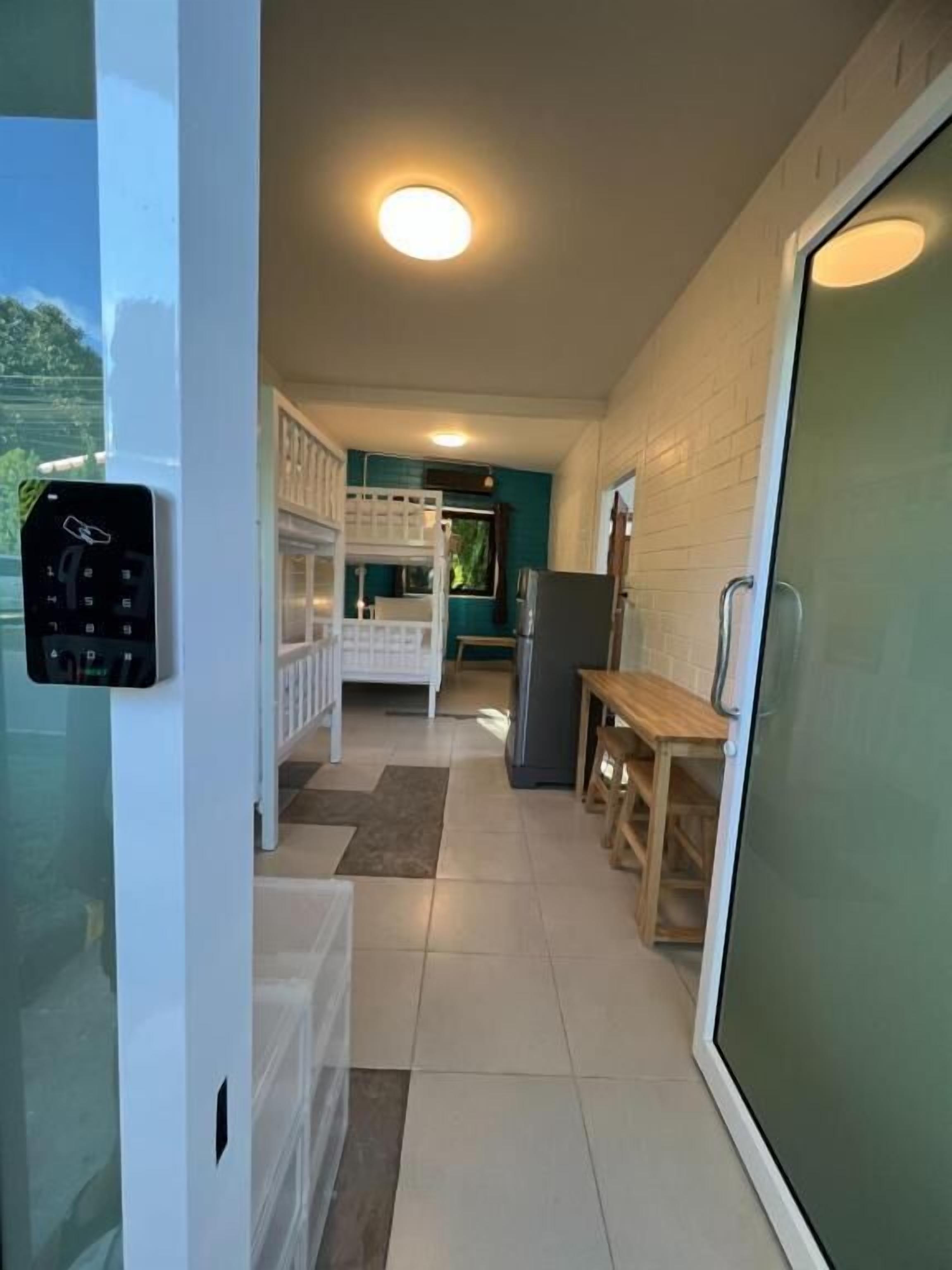 A compact kitchen with a refrigerator, a bench, and a window.