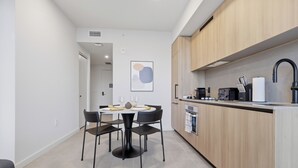 A modern kitchen with wooden cabinets, a built-in oven, and a sink. - AEA - 121 NE 5th St Miami (Miami)