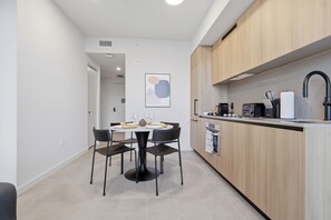 A modern kitchen with wooden cabinets, a built-in oven, and a sink. - AEA - 121 NE 5th St Miami (Miami)
