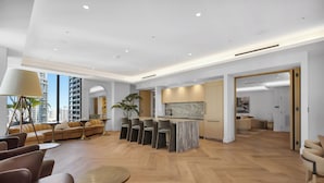 A spacious living area with a kitchen, seating, and a view of the city. - AEA - 121 NE 5th St Miami (Miami)