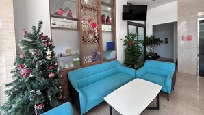 A lobby with a Christmas tree, blue sofas, and a white table. - JBAY Riverfront Boutique Hotel (Da Nang)