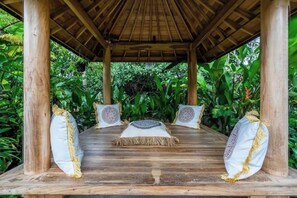 A wooden gazebo with a thatched roof, surrounded by lush greenery. - Chakola Villa (Ubud)