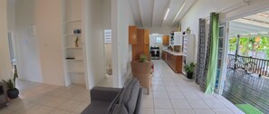 A spacious living area with a sofa, a dining table, and a kitchen in the background. - Family - Friendly 2BR Home - Safe Area, Walk to Food, Shops & Playing Field (Rodney Bay)