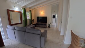 A living room with a sofa, TV, and a large mirror. - Family - Friendly 2BR Home - Safe Area, Walk to Food, Shops & Playing Field (Rodney Bay)