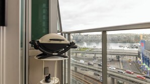 Et vindue med udsigt til en livlig motorvej og et vandområde.