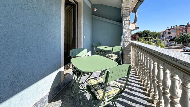 A balcony with a tiled floor, a railing, and a table with chairs. - Apartment Ivo by Interhome (Pula/Banjole)