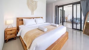 Habitación de hotel moderna con una cama grande, una mesita de noche, un cuadro en la pared y vistas a través de un ventanal.