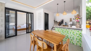 Una cocina moderna con comedor, una escalera y vista a un dormitorio.