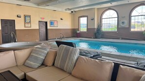 Ein Poolbereich im Innenbereich mit einer Sitzecke und einem Whirlpool.