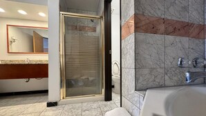 A modern bathroom with a glass-enclosed shower, a large bathtub, and a marble-tiled floor. - FairBridge Inn & Suites Thermopolis (Thermopolis)