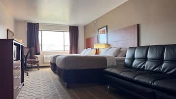 Ein Hotelzimmer mit Bett, Sofa, Schreibtisch und Stuhl.