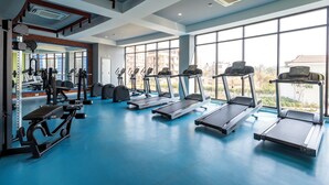 Ett gym med löpband, styrketräningsmaskiner och ett blått golv.