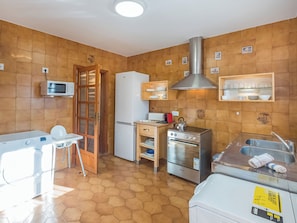 A compact kitchen with a microwave, refrigerator, oven, and a sink. - Dofins Bahia Azul by Interhome (Llucmajor)
