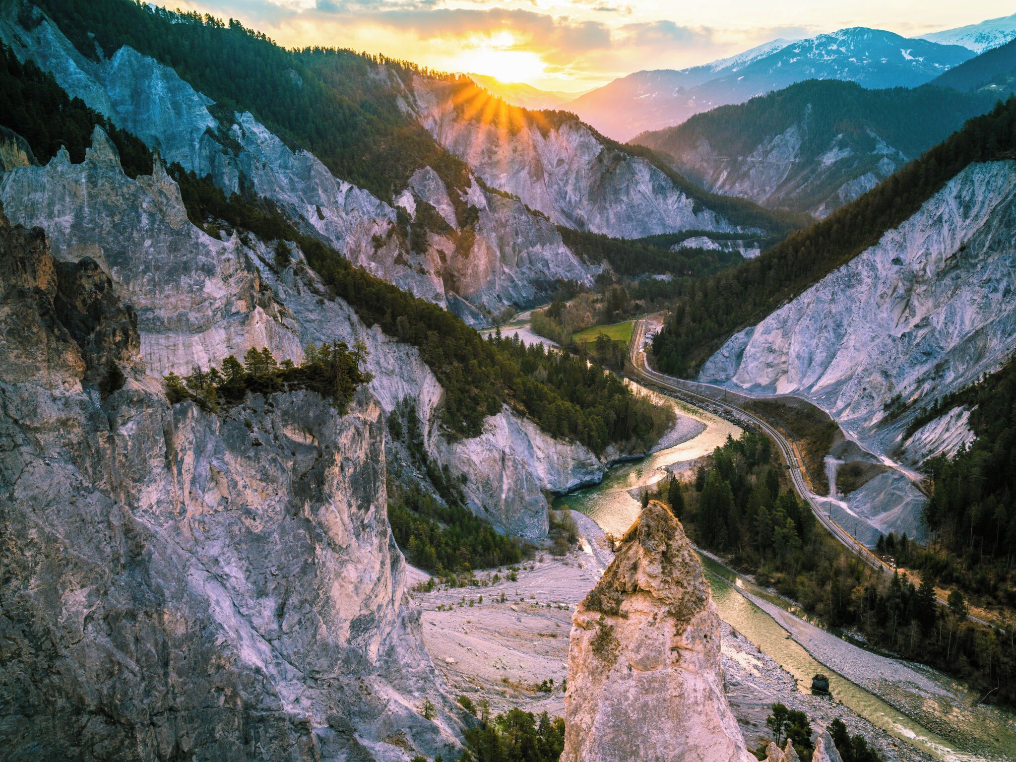 A mountainous landscape with a winding road through a valley.
