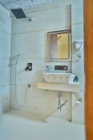 A bathroom with a shower, a vanity with a mirror, and a telephone. - emersion residency (PUNE)