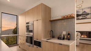 Uma cozinha moderna com eletrodomésticos embutidos, uma janela ampla e uma lareira.