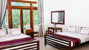 A hotel room with two beds, a desk, a chair, a mirror, and a window with curtains.