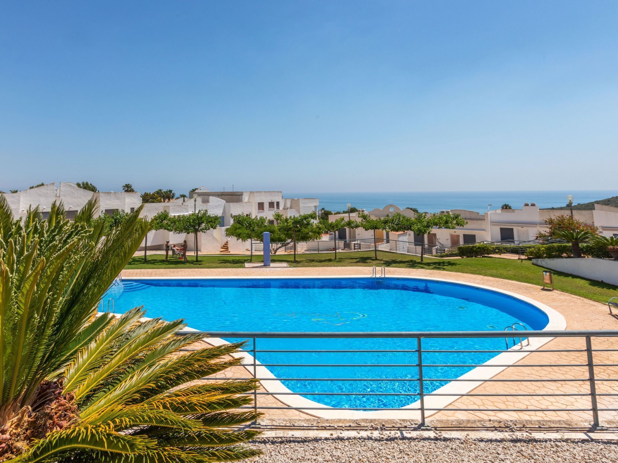 Una piscina con vista despejada al mar, rodeada de edificios de diseño moderno.