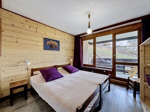 Ein Zimmer mit Holzwänden, einem Bett und einem Bärenbild.