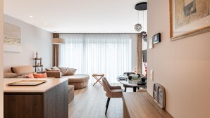 Een moderne woonkamer met een bank, een eettafel en een keukenhoek.