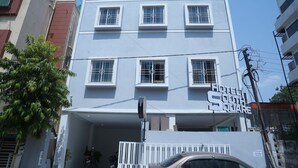 Un immeuble à plusieurs étages portant une enseigne indiquant « Hôtel South Square ».