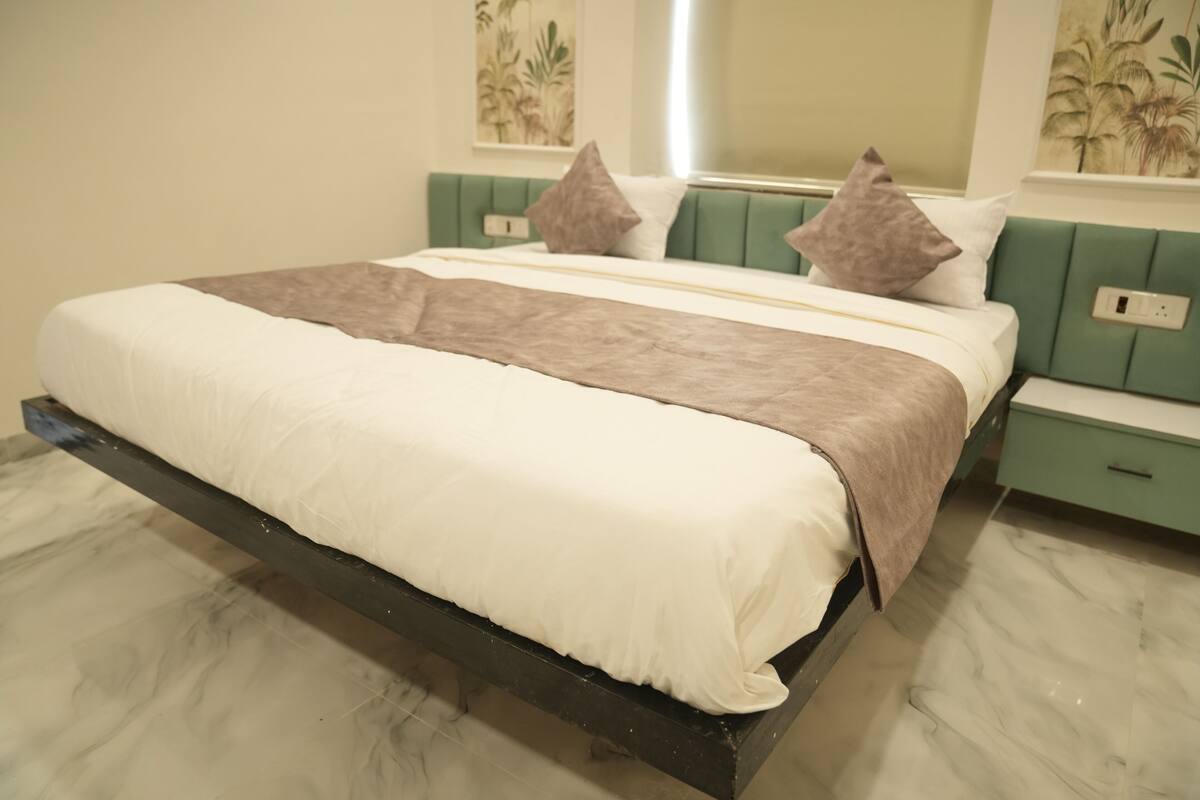A bed with a headboard, pillows, and a bedside table.