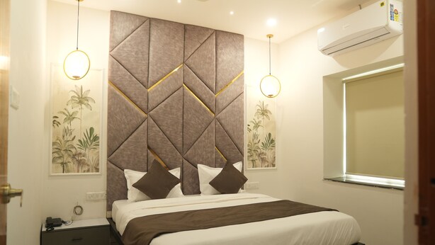 Une chambre à coucher comprenant un lit, une table de chevet, des œuvres d’art murales et un appareil de climatisation.