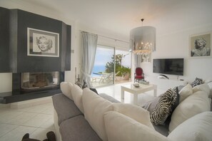 A modern living room with a sofa, a TV, and a fireplace. - FRGK Magnificent See View Villa with Monaco backgr (Beausoleil)