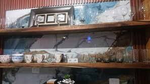 A shelf with various glassware and ceramic items, including cups and bowls. - Luxury apartment with a pool and hot water—offering comfort, and pets are welcom (Bonao)