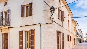 Straßenansicht eines Gebäudes mit mehreren Fenstern, einer sichtbaren Tür und einer Straßenlaterne.