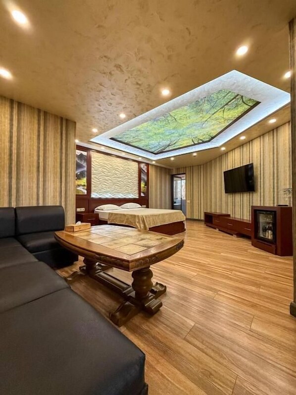 A room with a skylight, a sofa, a table, and a TV. - Israel Ori Hotel (Yerevan)