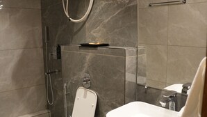 A modern bathroom with a toilet, bidet, and shower. - Trevon Twin Tree Inn (Dhanbad)