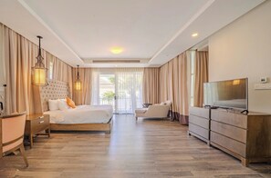 A hotel room with a bed, a desk, a TV, a dresser, and a chair. - Terra Garden Pool Village (Ngu Hanh Son)
