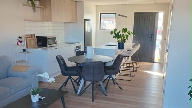 Una sala de estar moderna con un sofá, una mesa de centro y un comedor con sillas y una mesa.