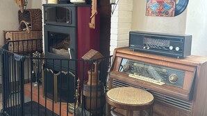 Une radio ancienne, une malle en bois, une chaise en osier et une horloge murale.