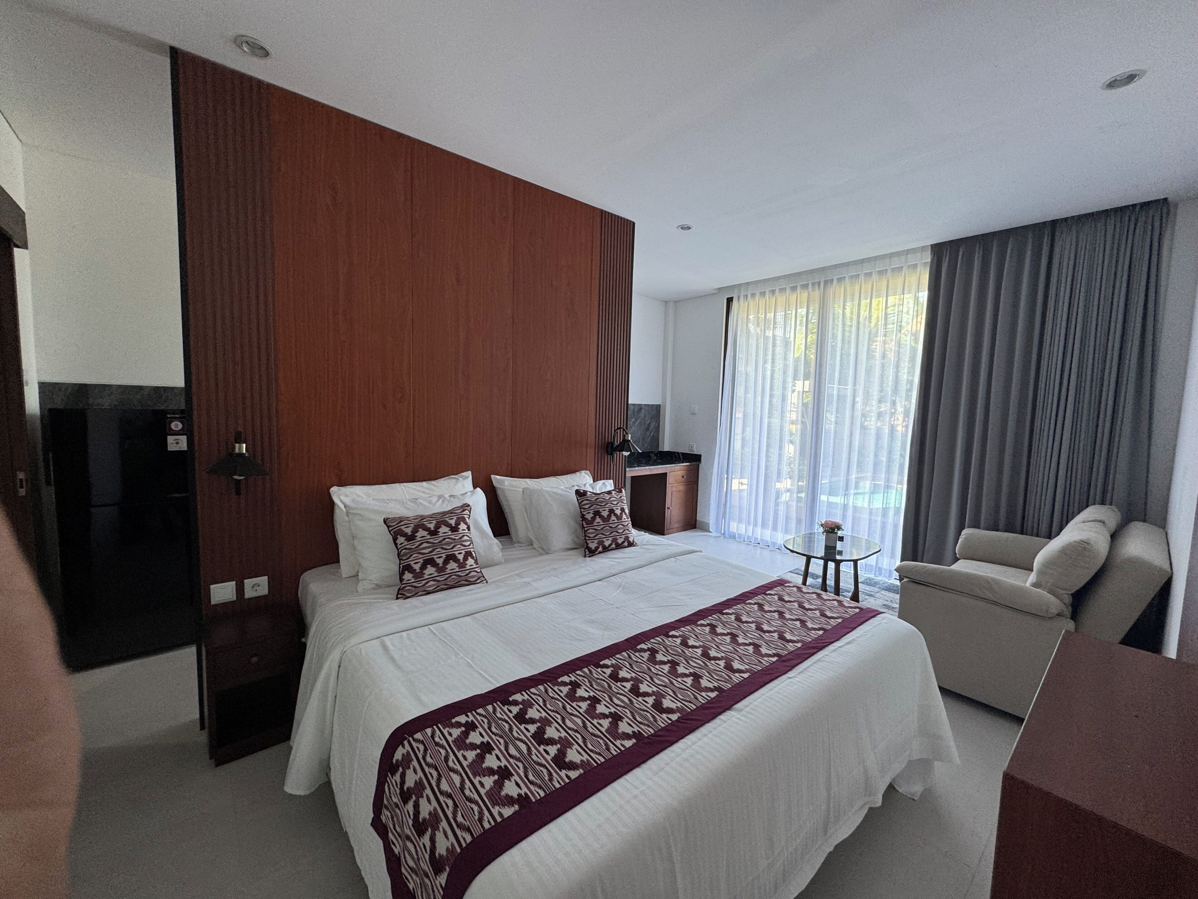 Una habitación de hotel con una cama grande, un escritorio, una silla y un televisor.